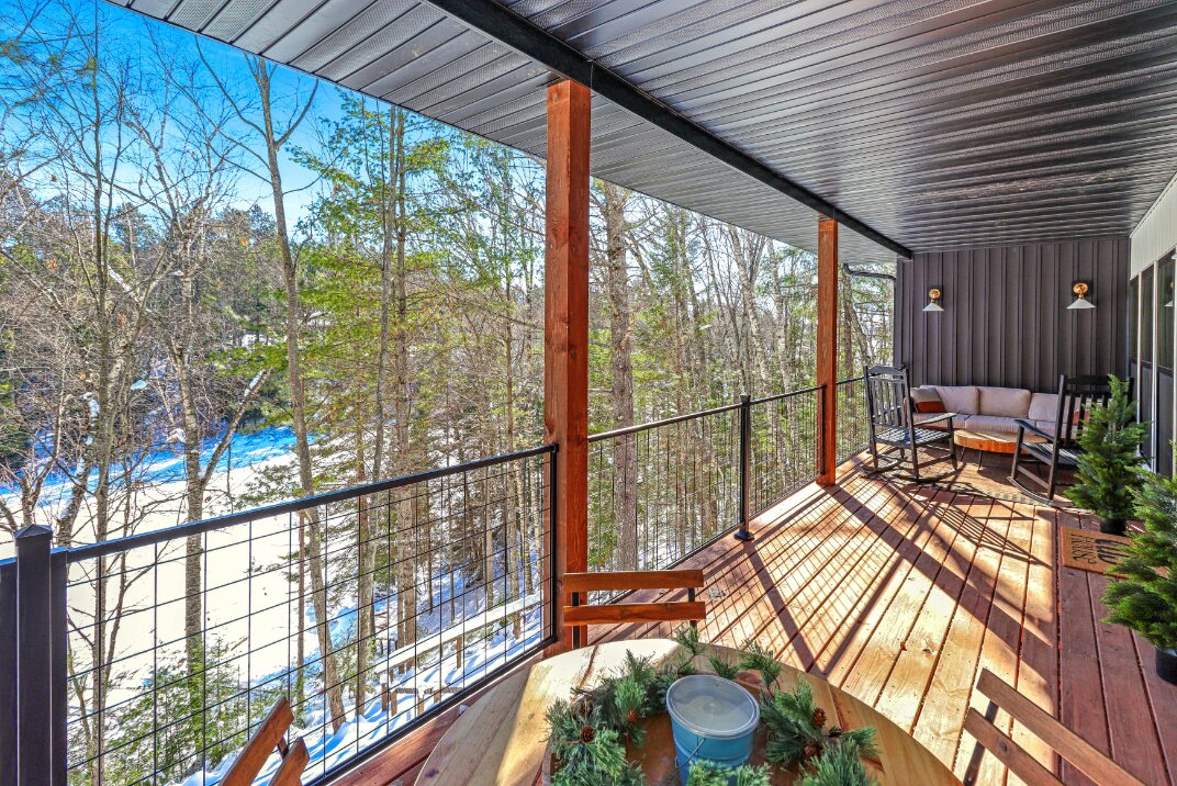 Upper covered deck overlooking the river and woods