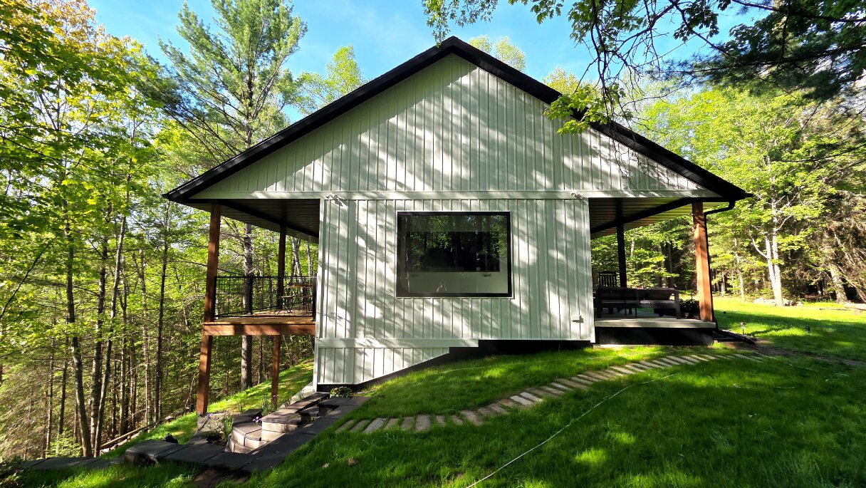 The Cub House exterior, covered porches, and summer landscaping