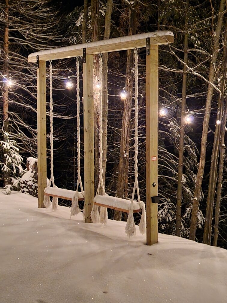Hillside swings beneath string lights in winter