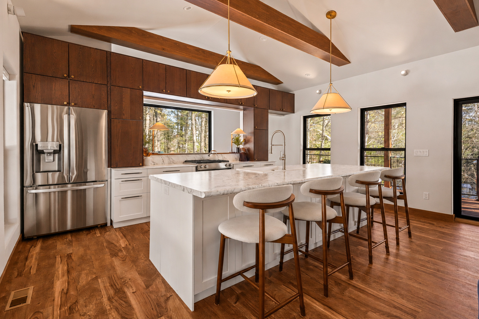 Twelve-foot marble island and walnut kitchen beneath vaulted beams