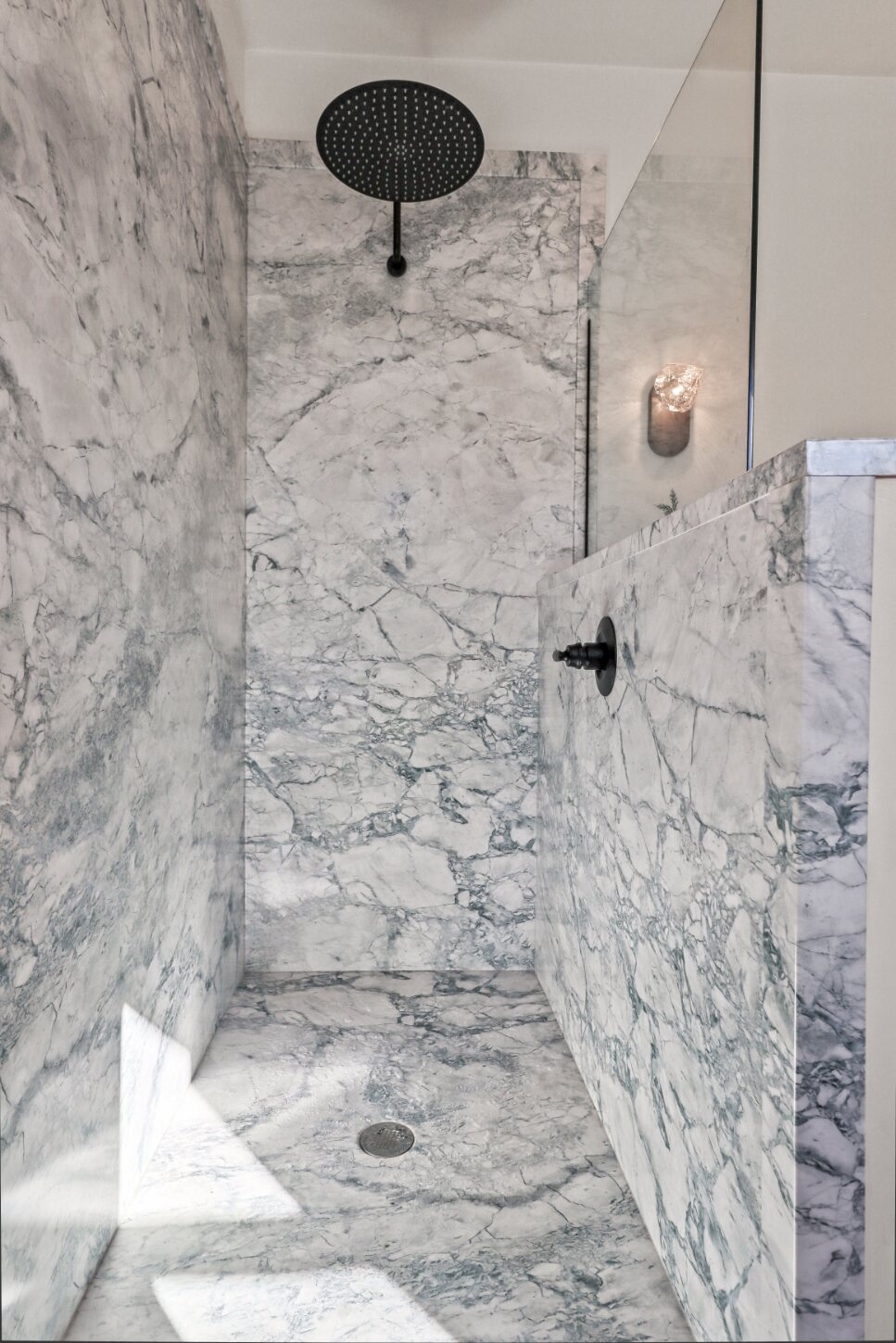 Primary suite marble walk-in shower with rain head